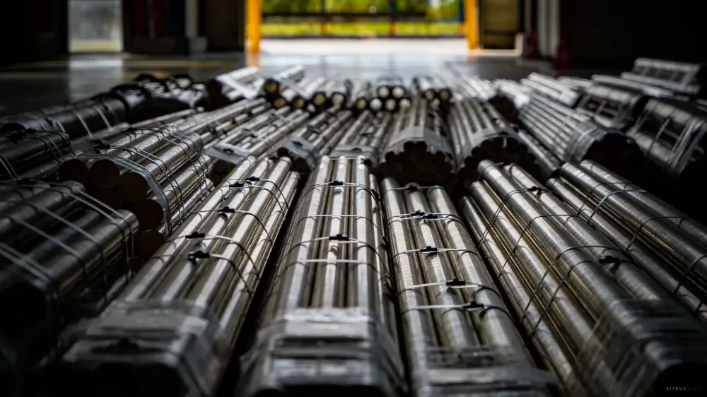 Strapped bundles of copper alloy bars lying on a warehouse floor